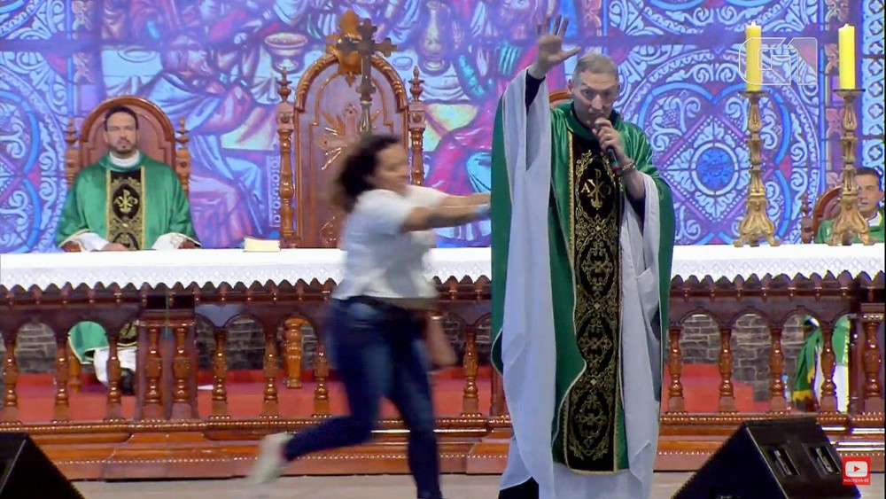 Mulher empurra Padre Marcelo Rossi durante missa na Canção Nova, em São Paulo (foto: Reprodução)